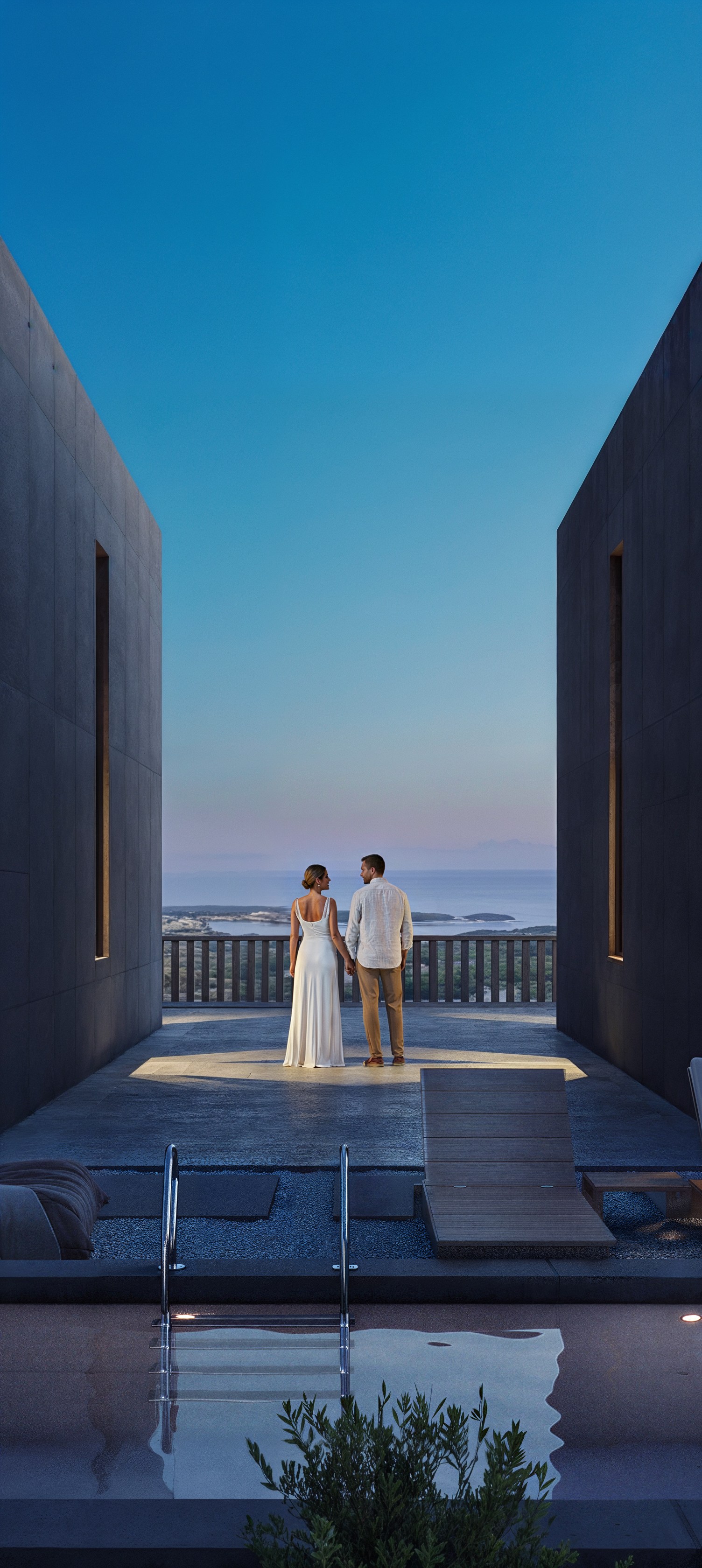 Couple between concrete volumes with lit pool and sea horizon