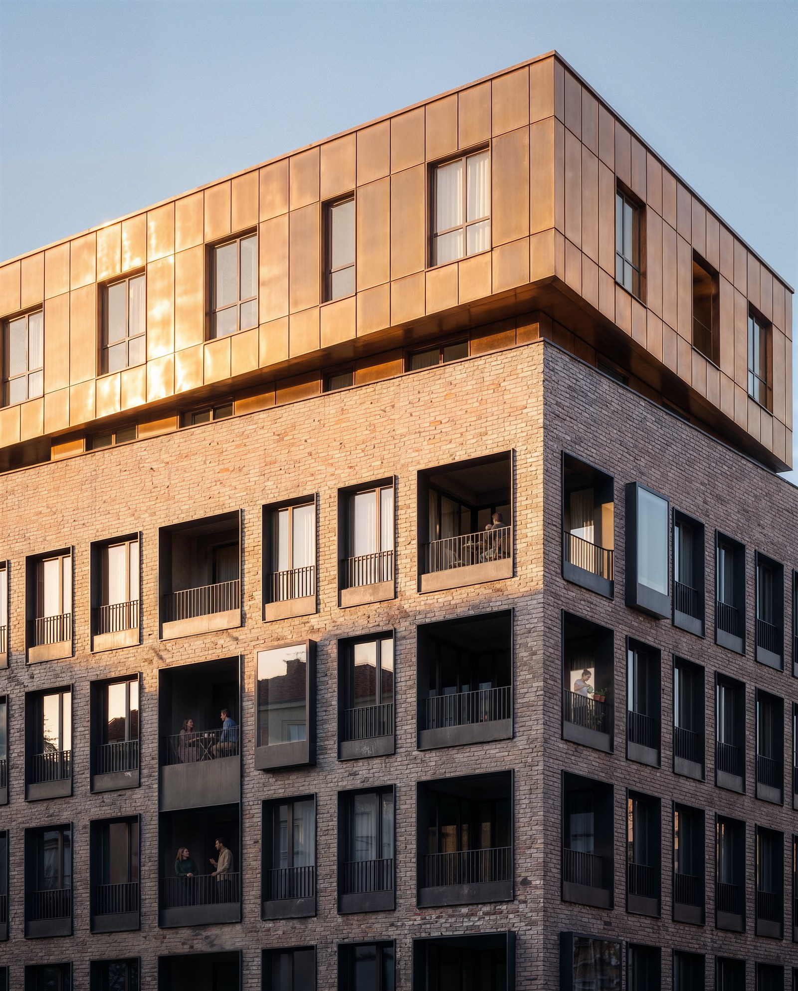 Copper crown over a brick facade with residents on the balconies