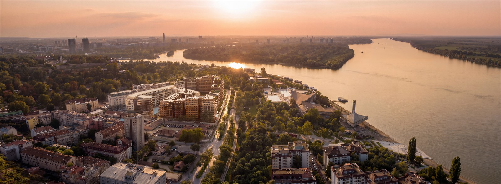 Aerial of the river bend and riverside blocks in golden haze