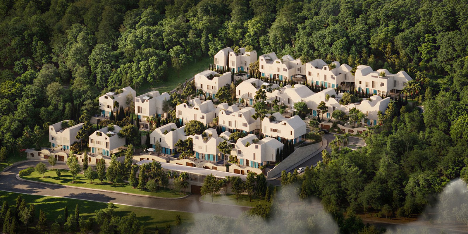 Aerial of a white village cluster nested in a dense green hillside