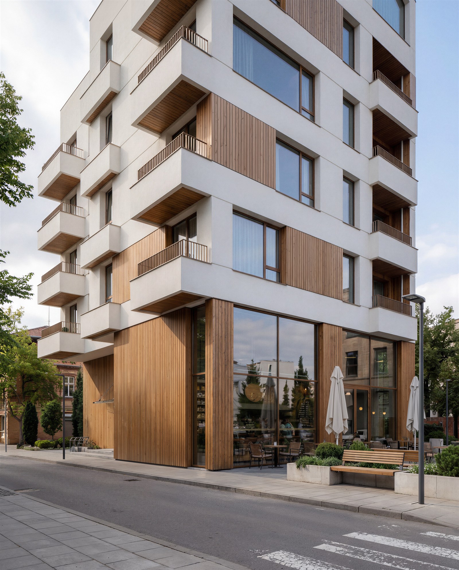 Timber-clad corner cafe under a white balconied residential block